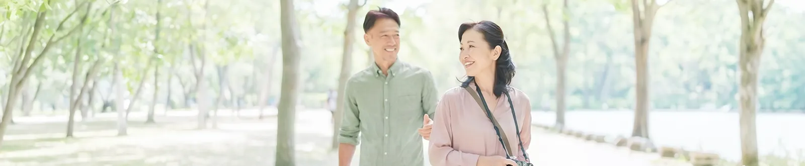 公園を歩きながら会話する男女の写真