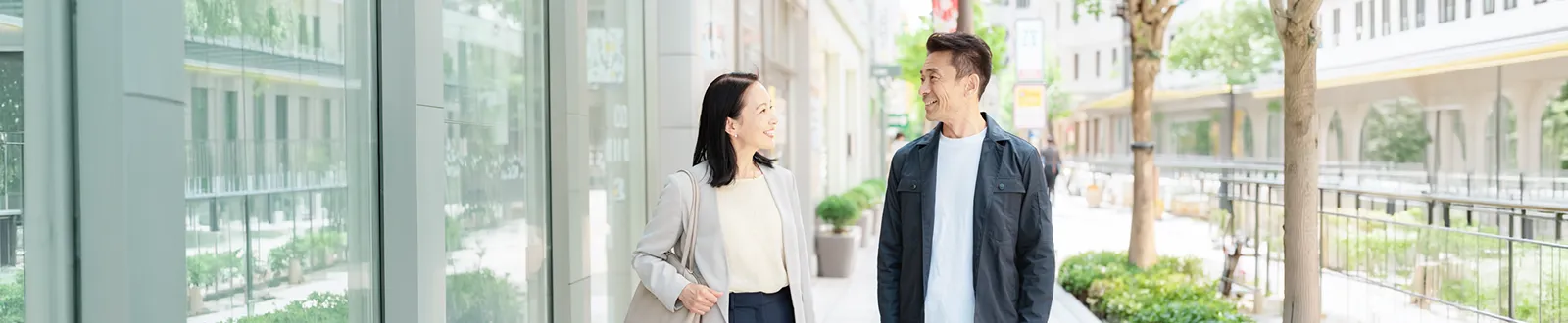 街を歩きながら会話する男女の写真
