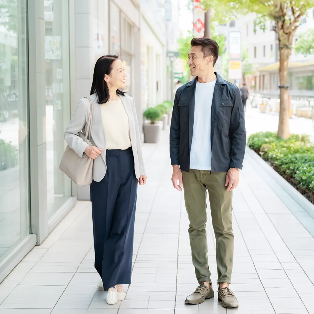 街を歩きながら会話する男女の写真
