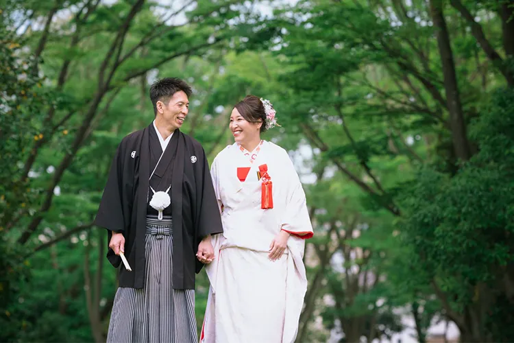 緑の中を歩く和装姿の夫婦